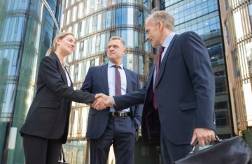 successful-business-people-meeting-city-shaking-hands-near-office-building-low-angle-shot-communication-partnership-concept_74855-7814